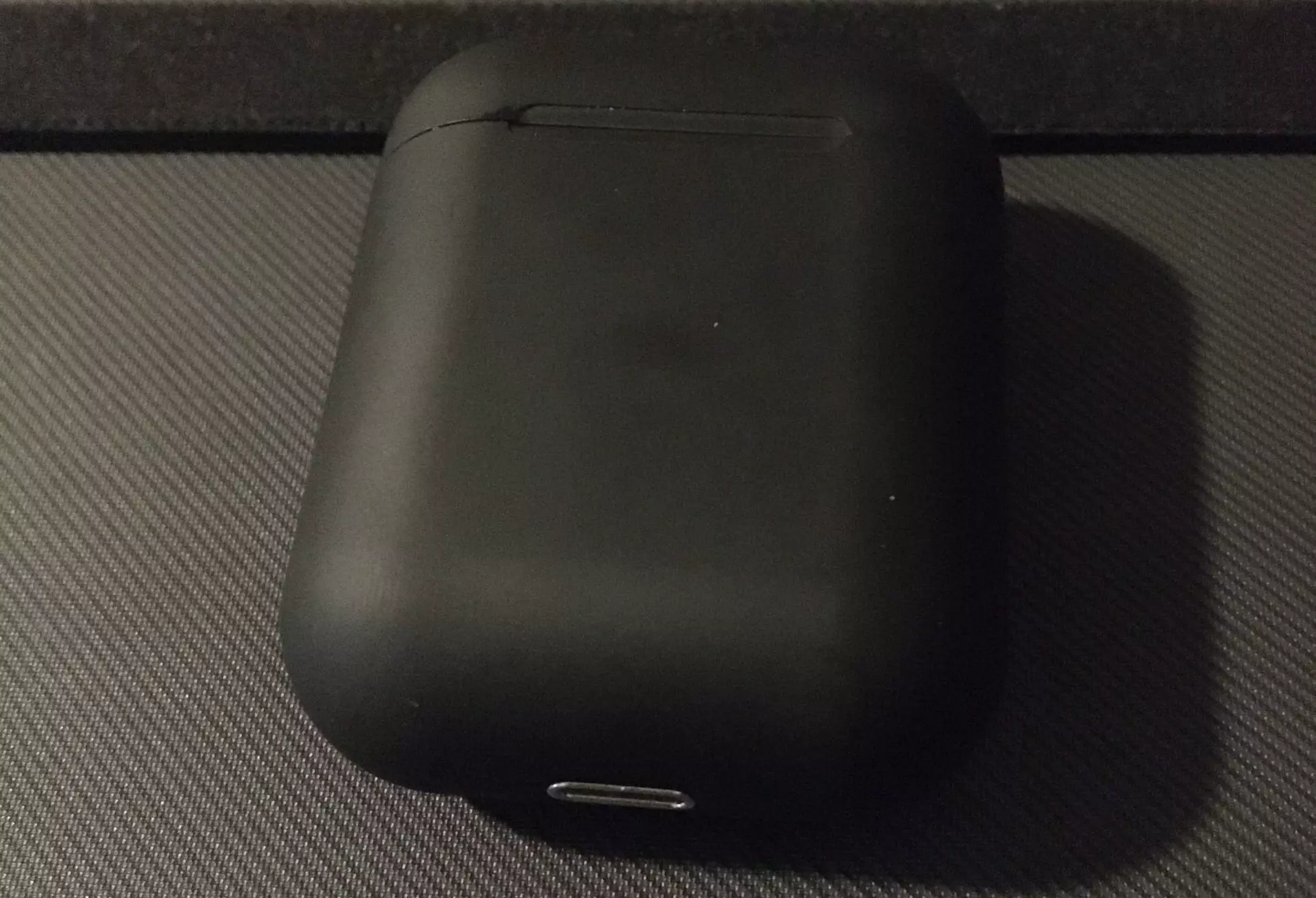 AirPods case resting flat with the lid shut